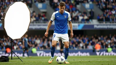 A photorealistic image of an anonymous Sochaux player, aged 25-30, wearing a blue jersey with white sleeves and white...