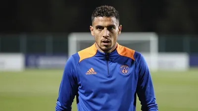 A determined, athletic Auxerre midfielder, 25, with a strong build, wears a plain blue and amber training top, captured...