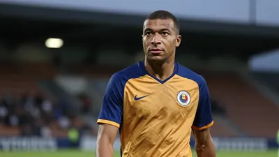 A 35-year-old, 5'10" Auxerre midfielder, dressed in a plain blue and amber jersey, stands in the tunnel at Stade de...