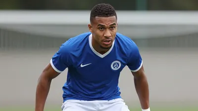 A photorealistic image of an anonymous Auxerre player, wearing a blue jersey with white shorts, in a tight action crop...