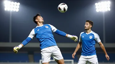 A 30-year-old male goalkeeper with a strong build, wearing a blue jersey with white sleeves and white shorts, making a...